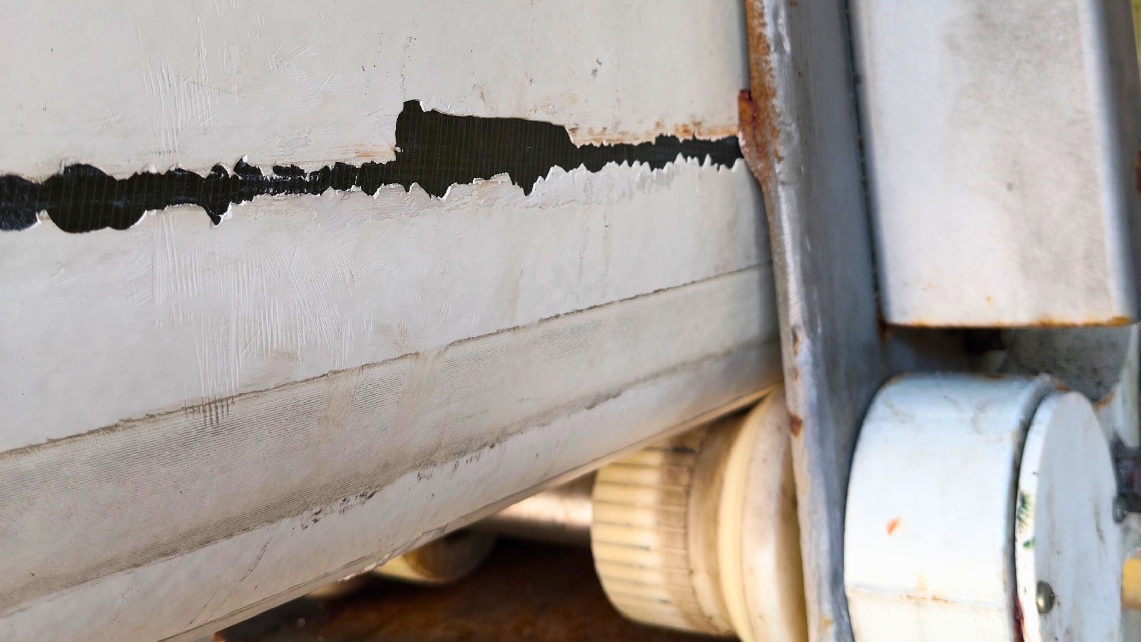 Close-up of EWP boom scrape caused by worn rollers exposing fibreglass