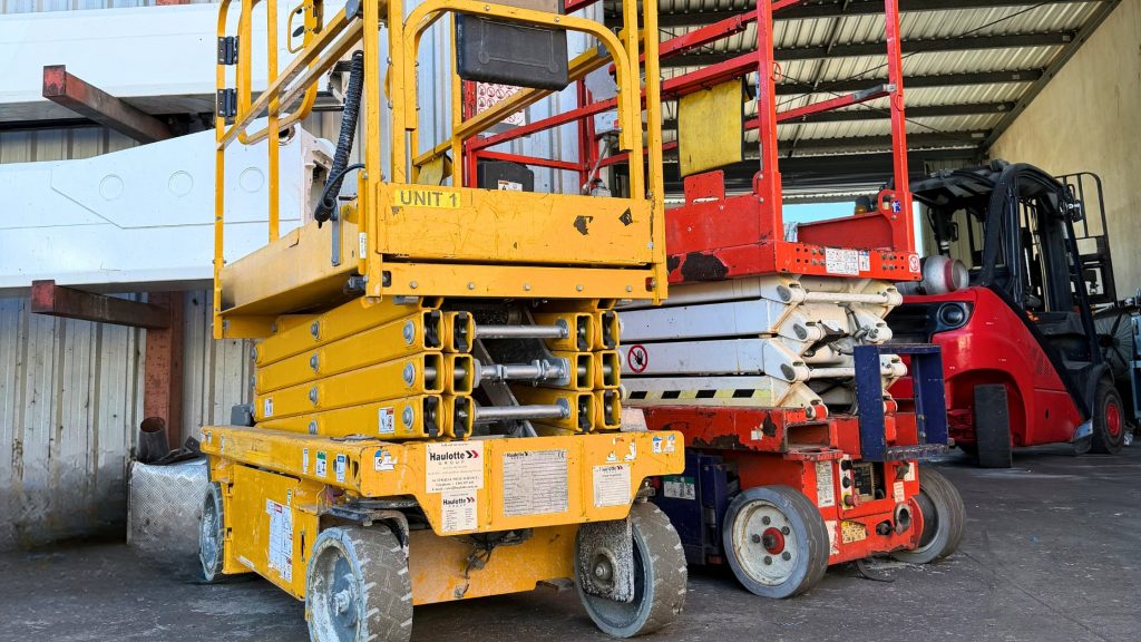 Technician carrying out a 90-day inspection on a scissor lift