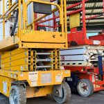 Technician carrying out a 90-day inspection on a scissor lift