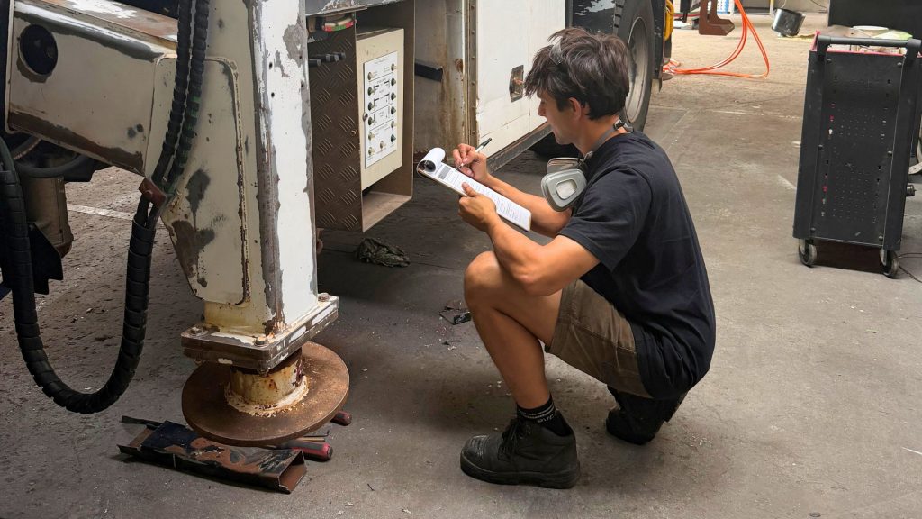 Technician assessing an elevated work platform after inspection findings