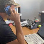 EWP Systems technician discussing repair or replacement options while reviewing a customer's elevated work platform.